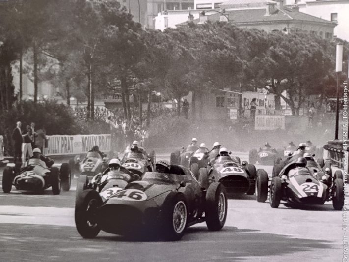 Jean Behra au volant de sa Ferrari, en tête au premier virage du Grand Prix de Monaco 1959 devant Stirling Moss - Photo : Bernard Cahier