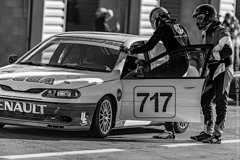 Voiture de course Renault avec le numéro 717, un pilote entrant par la porte du conducteur.
