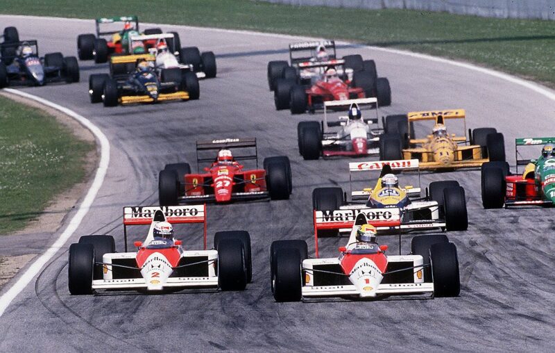 Ayrton Senna (n° 1) dépasse son coéquipier chez McLaren, Alain Prost (n° 2), dans le virage de Tosa sur le circuit d'Imola, lors du nouveau départ du Grand Prix de Saint-Marin de Formule 1 en 1989. Le pilote brésilien a effectué cette manœuvre sur le Français malgré un accord préalable, conclu aux stands, de ne pas attaquer le pilote en tête à l'entrée de ce virage lors du premier tour ; la rupture de ce pacte a déclenché ce que l'on a appelé la « guerre de Tosa », attisant définitivement la rivalité féroce entre Prost et Senna.
