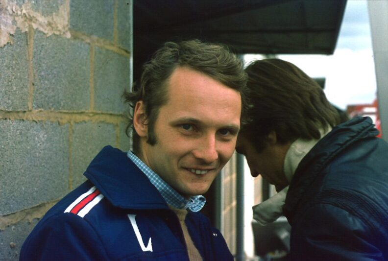 Niki Lauda aux stands de Silverstone avec Carlos Reutemann en arrière-plan, Grand Prix de Grande-Bretagne 1975.